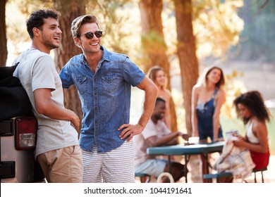 Two Young Men Hanging Out With Friends By A Lake