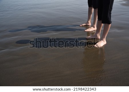 Two young men on the seashore on the beach with bare feet