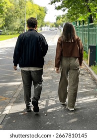 Two young men are walking down the street, one in a black jacket and the other in a brown jacket. It's a guy and a girl. Russia. Moscow. 19.08.25