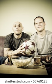 Two Young Men Watching A Football Match On Tv. Sport Fans