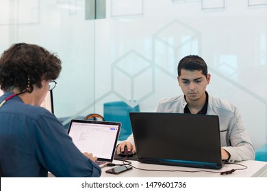 Two young men working at the computer in coworking office.