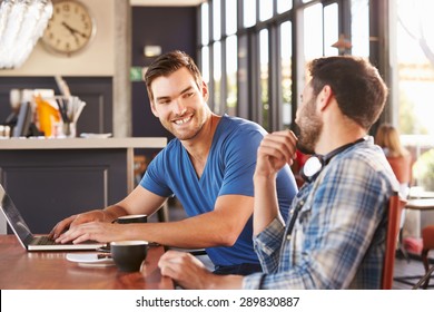 Two Young Men Working On Computers At A Coffee Shop