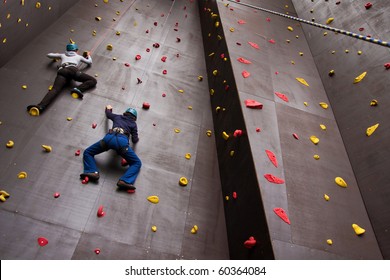 Two Young People Climbing On Wall