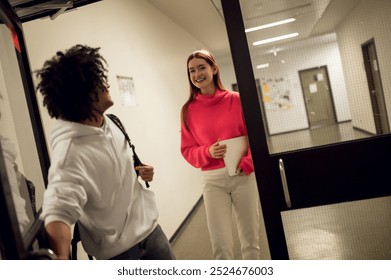 Two young people in the corridor talking and looking involved