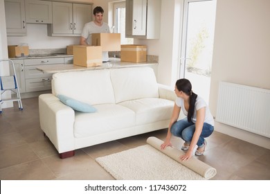 Two Young People Moving Into Their House And Furnishing The Living Room