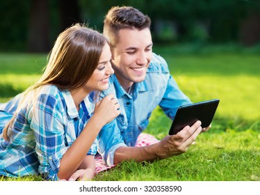 Two Young People With A Tablet Outside 