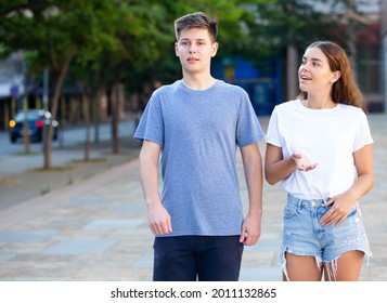 Two young people are walking on the street