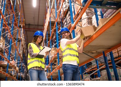 Two Young People Working Together In Warehouse Storage Facility. Checking Goods At Distribution Warehouse.