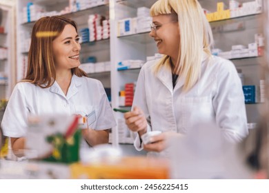 Two young pharmacists at the cash desk of pharmacy store. Talking about medicine. - Powered by Shutterstock