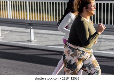 Two Young Plus Size Women Jogging Together.