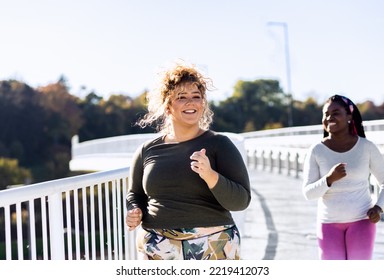 Two Young Plus Size Women Jogging Together.