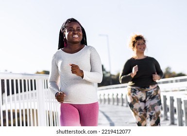 Two Young Plus Size Women Jogging Together.