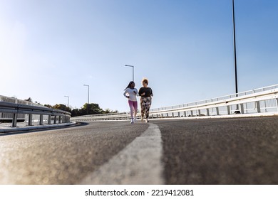 Two Young Plus Size Women Jogging Together.