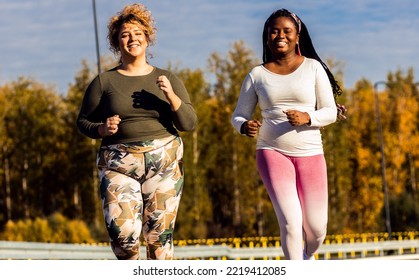 Two Young Plus Size Women Jogging Together.