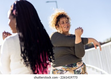 Two young plus size women stretching together before running. - Powered by Shutterstock