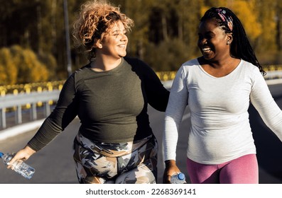 Two young plus size women jogging together.