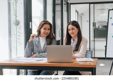 Two young pretty asia business woman in suit talking together in modern office workplace, Thai woman, southeast asian - Shutterstock ID 2254881081