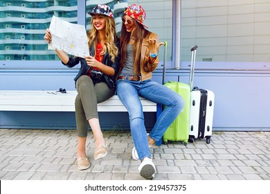 Two young pretty girls exploring and looking on map before their traveling adventures, smiling and having fun before new emotions. Best friend posing with their luggage. - Powered by Shutterstock