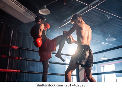 Dos jóvenes boxeadores profesionales compitiendo en el escenario. Atacantes atletas masculinos luchadores musculares sin camisa y golpeando a la competidora disfrutando del ejercicio de boxeo en el ring en el estadio.