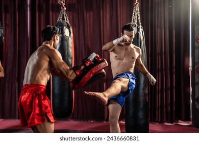 Two young professional boxer having a competition tournament on stage. Attractive male athlete fighters muscular shirtless punches and hitting competitor enjoy boxing exercise in the ring at stadium. - Powered by Shutterstock