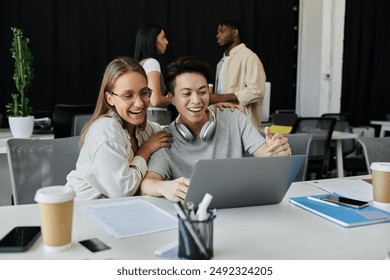 Two young professionals celebrate a breakthrough while working on their startup in a modern office. - Powered by Shutterstock