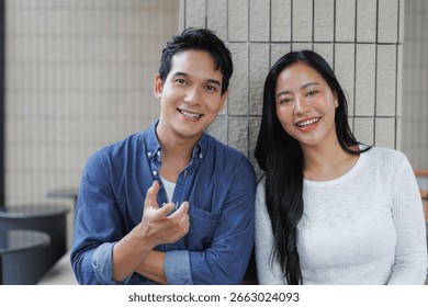 Two young professionals are smiling and sharing inspiring ideas, showcasing teamwork and collaboration in a modern office environment