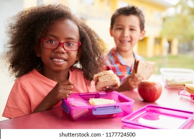 Two Young School Kids Eating Their Packed Lunches Together