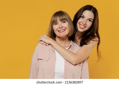 Two young smiling satisfied daughter mother together couple women wearing casual beige clothes looking camera hug isolated on plain yellow color background studio portrait. Family lifestyle concept - Shutterstock ID 2136382897