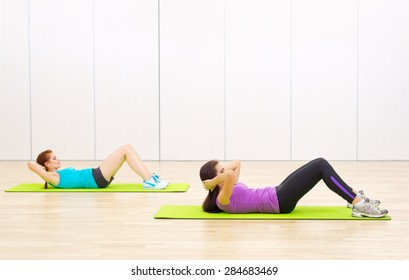 Two young sporty women at fitness club
