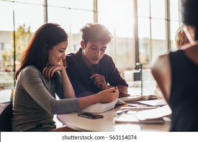 Two Young Students Reading A Book In Library. University Students Studying Together In Class.