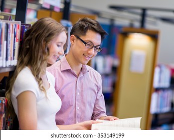 Two Young Students Working Together At The Library