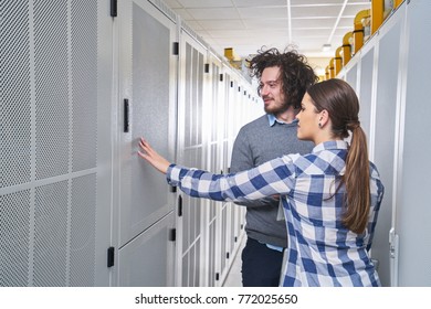 two young technicians working at a data center on server maintenance