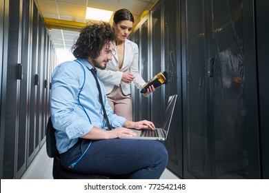 two young technicians working at a data center on server maintenance