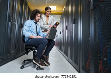 two young technicians working at a data center on server maintenance