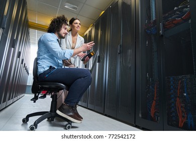 two young technicians working at a data center on server maintenance