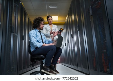 two young technicians working at a data center on server maintenance