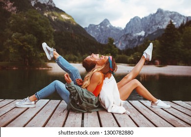 Two young tourist women have fun on the dock on lake - Powered by Shutterstock