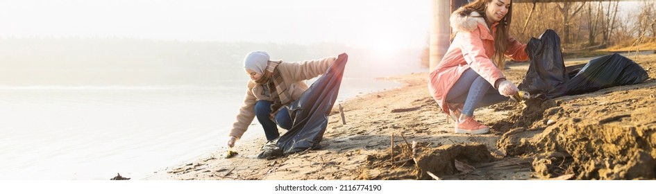 Two young volunteers cleaning up the beach from various trash - Powered by Shutterstock