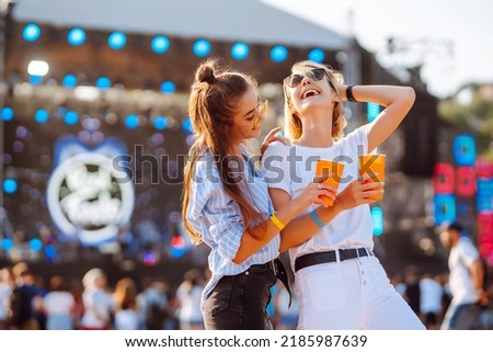 Two young woman with beer at beach party. Summer holiday, vacation concept. Friendship and celebration concept.