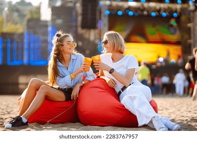 Two young woman  with beer at music festival. Beach party, summer holiday. - Shutterstock ID 2283767957