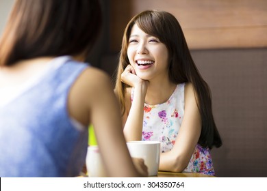 Two Young Woman Chatting In A Coffee Shop