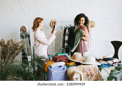 two young woman female caucasian and african students at swap party try on clothes, bags, shoes and accessories, change clothes with each other, second hand for things, zero waste life, eco-friendly - Shutterstock ID 2180999929
