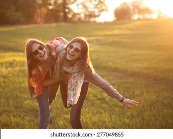 Two young woman making fun on nature at sunset - Powered by Shutterstock