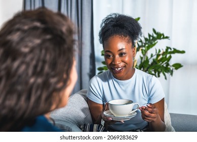 Two Young Women Best Friends Sitting On The Sofa At Home Drinking Tea Or Coffee Complaining On Her Boyfriend Or Husband To How He Changed And Become Jealous, Selective Focus