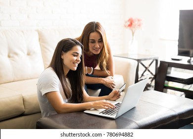 Two Young Women And Best Friends Doing Some Online Shopping At Home With A Laptop And A Credit Card