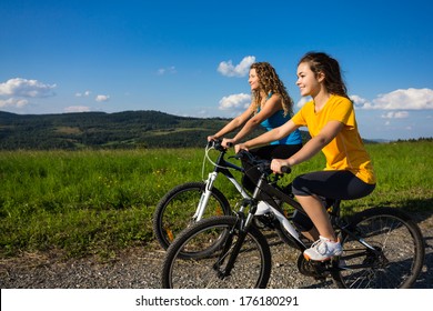 Two Young Women Biking 