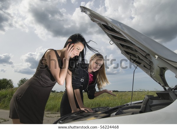 Two young women with\
broken down car