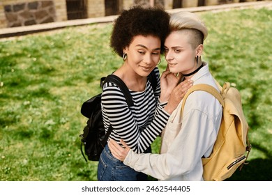 Two young women, in casual attire, embrace lovingly in the grassy field, sharing a moment of genuine connection. - Powered by Shutterstock