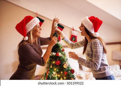 Two Young Women Decorating Christmas Tree.