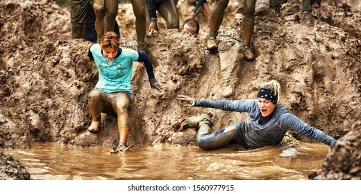 Two Young Women Doing a Mud Race Challenge - Powered by Shutterstock